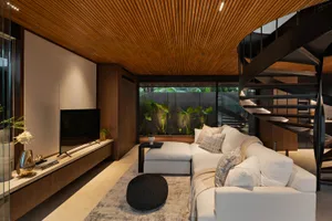 Modern living room with white sectional sofa, wooden ceiling, and spiral staircase.