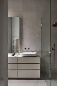 Minimalist bathroom featuring gray tile and concrete materials, showcasing sleek and modern design.