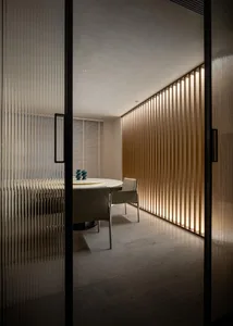 A minimalist dining room with wooden walls and lighting