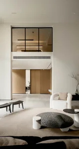 Contemporary minimalist living room with concrete flooring, wood-paneled walls, and a modern white armchair.