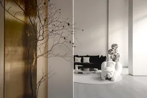 A minimalist living room with a white couch, black sofa, and a polar bear-shaped chair.