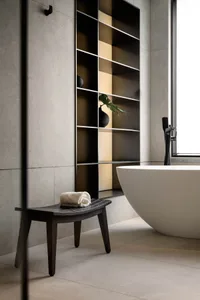 Modern bathroom interior with a concrete tile floor and wall, featuring a white freestanding bathtub and minimalist design el