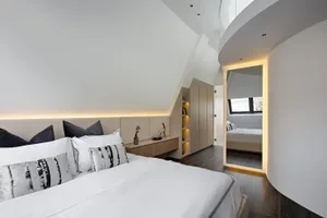 Modern bedroom featuring minimalist white decor and linear design elements.