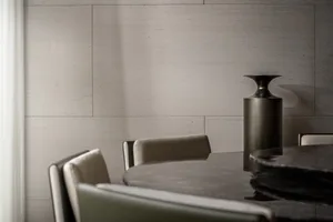 A modern dining room featuring a sleek, black marble dining table surrounded by contemporary chairs, with a minimalist aesthe