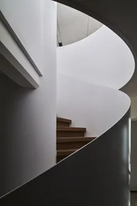 Spiral staircase with wooden steps and white walls