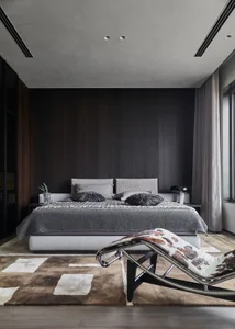 A modern minimalist bedroom featuring a bed with pillows and blankets