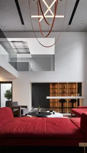 A modern reception lounge bar area with red sofas, bar stools, and a well-stocked bar.