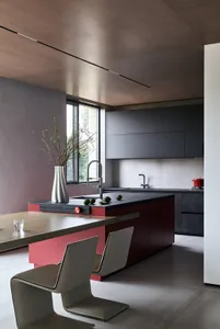 Modern, minimalist residential kitchen featuring a sleek concrete countertop and minimalist design elements.
