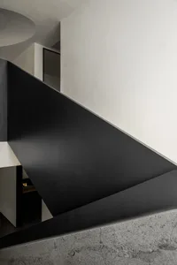 Modern interior design featuring a sleek, black metal staircase leading upwards