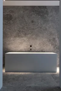 Modern, minimalist bathroom with a polished grey concrete floor and grey marble walls, featuring a minimalist bathtub.