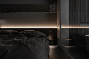 A minimalist bedroom with dark fabric bedding and warm ambient lighting.
