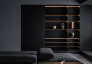 A modern minimalist black shelf with wood elements displaying decorative ceramic objects.