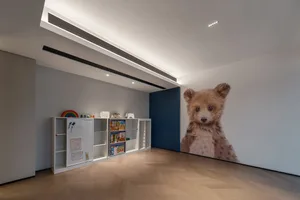 A modern children's playroom with a large bear mural on the wall.