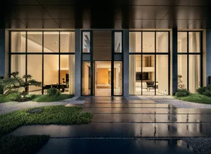 Modern house entryway featuring glass walls, cement floor, and wooden accents.