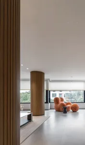 Modern living room with wood floor, white walls, and a red and white striped chair.