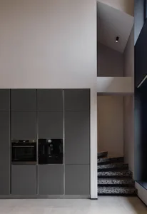 Modern kitchen with sleek gray cabinets and marble counters.