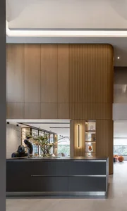 A modern kitchen with a wooden interior, featuring a dark countertop, white appliances, and minimalistic decor.