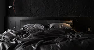 Modern minimalist bedroom with black textiles and white lighting
