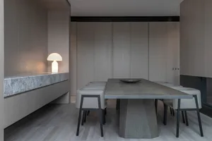 Modern minimalist dining room featuring a sleek concrete table and chairs.