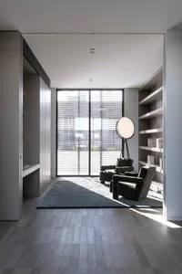 A cozy minimalist living room with wooden flooring and furniture.