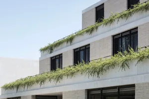 A modern office building with concrete exterior and greenery