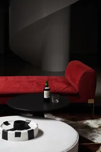A modern interior design featuring a textured red couch and a round black coffee table.