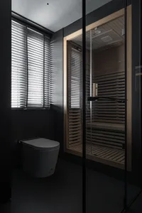 Modern black tiled bathroom with wooden shower cabin and glass door.