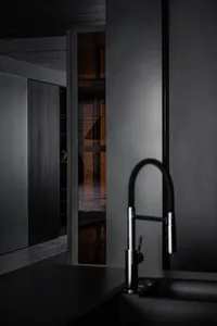A modern, black-on-black residential kitchen with sleek, minimalist design features.