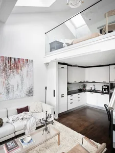 A modern minimalist living room with white furniture and a cozy atmosphere.