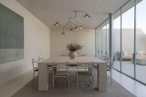 Modern dining room featuring a concrete table and chairs with a minimalist design.