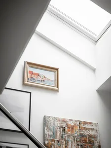 A modern interior featuring a painting artwork hanging on a white wall with a white ceiling.