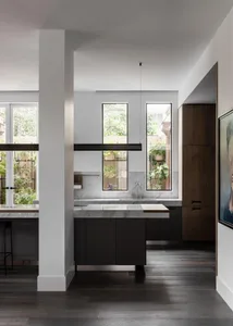 A modern interior space featuring concrete materials and tall windows.