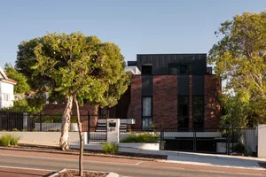 Modern residential home with brick exterior and black accents on roof.