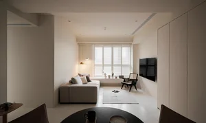 A minimalist living room with neutral-colored furniture and decor.