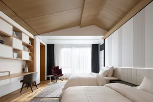 Modern bedroom featuring white beds and wooden walls with a clean, minimalist design.