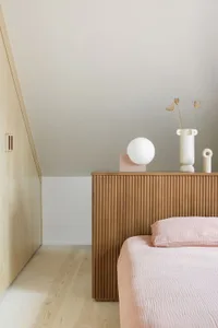 A modern bedroom featuring wooden elements and a cozy ambiance.