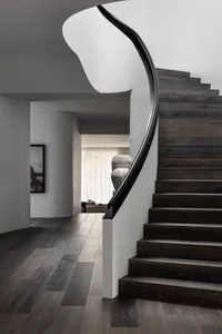 Modern black wood staircase with sleek, curved railings.
