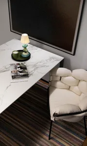 Modern home office featuring a marble lamp, white leather chair, and black frame