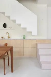 A modern kitchen featuring wooden cabinets and concrete flooring.
