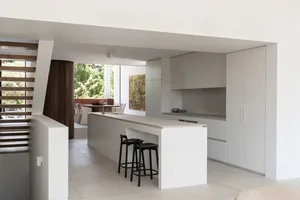 A modern residential kitchen with white surfaces and a large island.