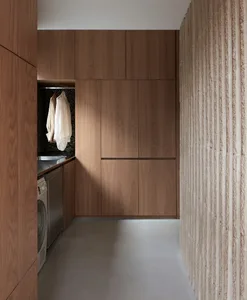 Modern laundry room featuring wood cabinets, concrete floor, and industrial-style design