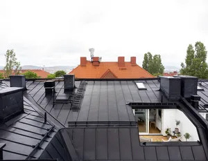 A modern rooftop featuring black metal roofing materials.