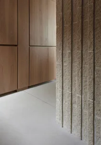 A modern interior space featuring concrete tiles on a wall and floor.