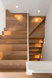 A modern wooden staircase with built-in lighting and a white handrail.