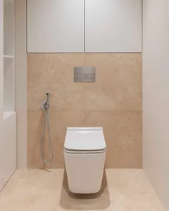 Modern bathroom with beige tiles and a sleek, white toilet.