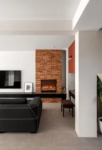 A modern living room featuring a brick fireplace and leather sofa.