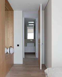 A minimalist bathroom with white lighting and wooden walls and floor.