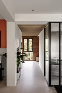 A minimalist residential entrance featuring brick, glass, and wood materials.