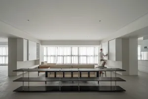 A modern living room with neutral-colored furniture and a minimalist design.