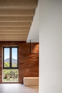 A modern residential interior featuring a brick wall and wood beams.